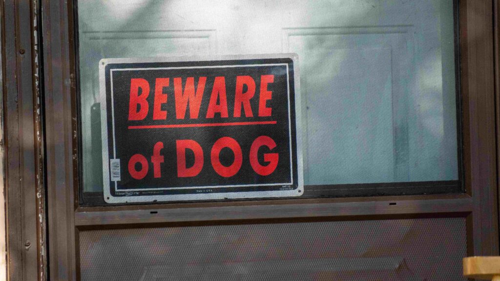 Beware of dog sign posted on a residential fence